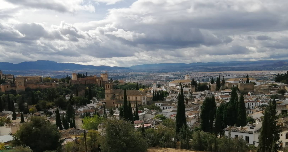 The whitewashed streets of the Albaicin quarter in Granada with the Alhambra visible across the valley