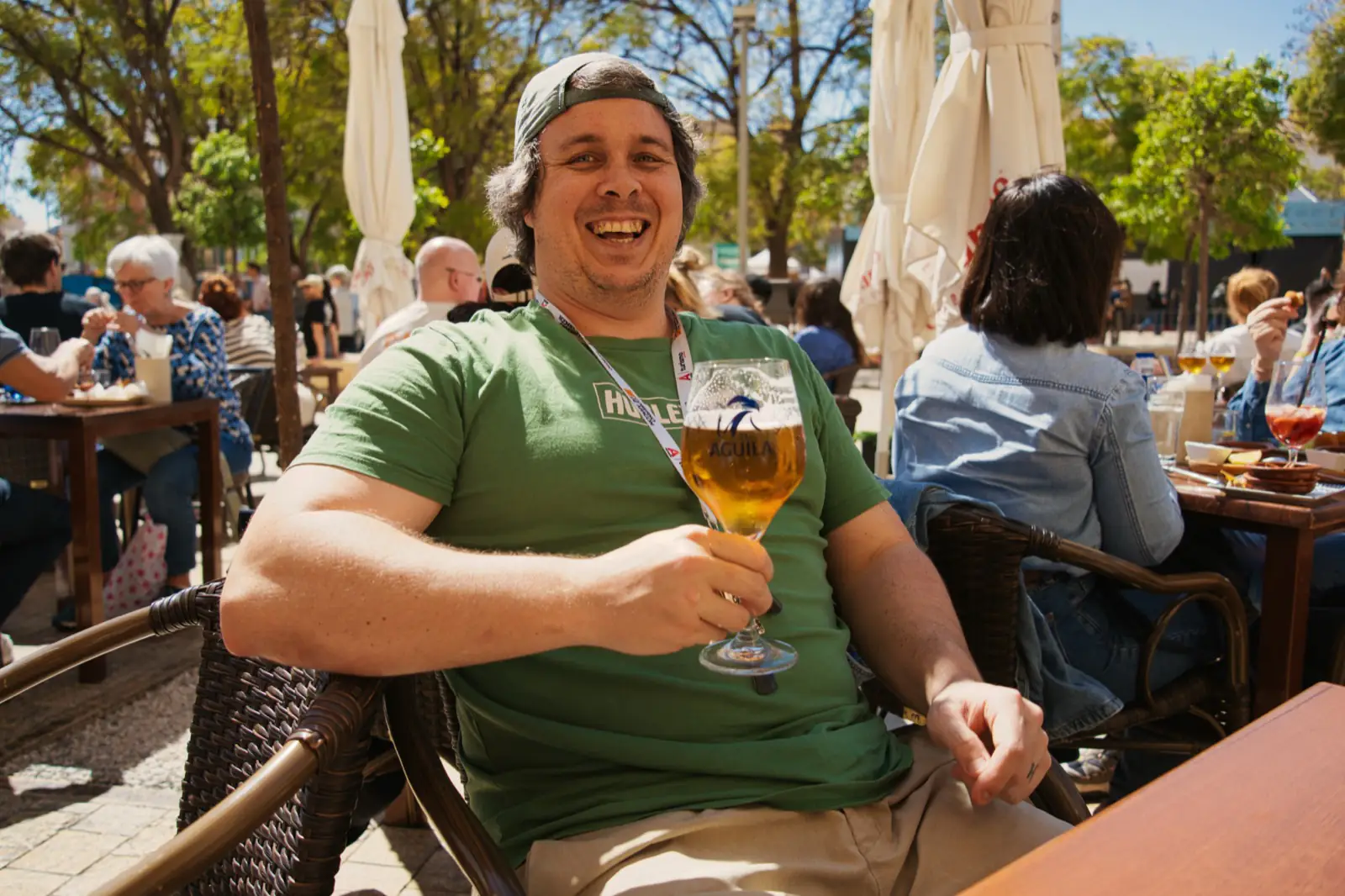 A man laughing while drinking a beer.