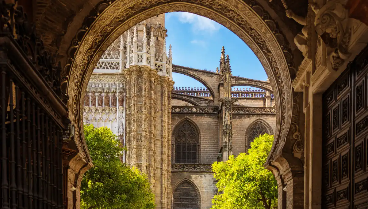 Seville Cathedral seen through a Moorish archway inside the Real Alcazar