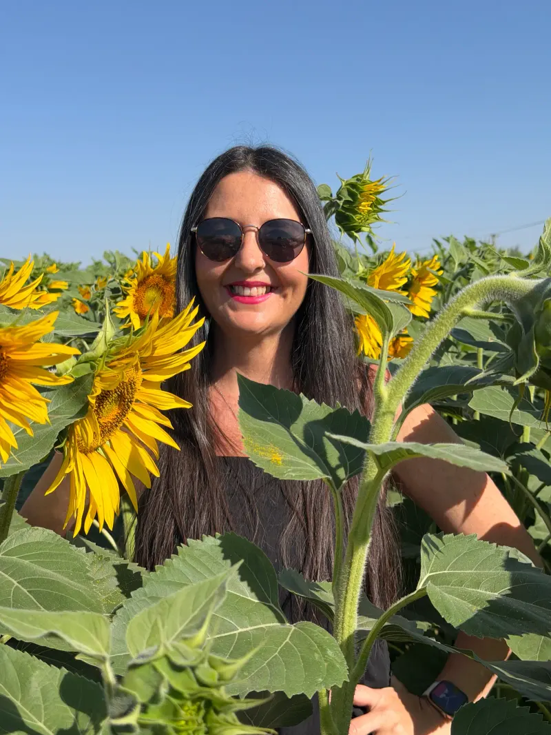 Heidi smiling in sunglasses in a sunflower field near Antequera