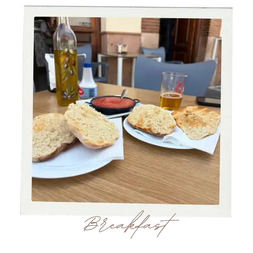 Two plates with pitufo rolls, a beer, and some tomato sauce on a table.