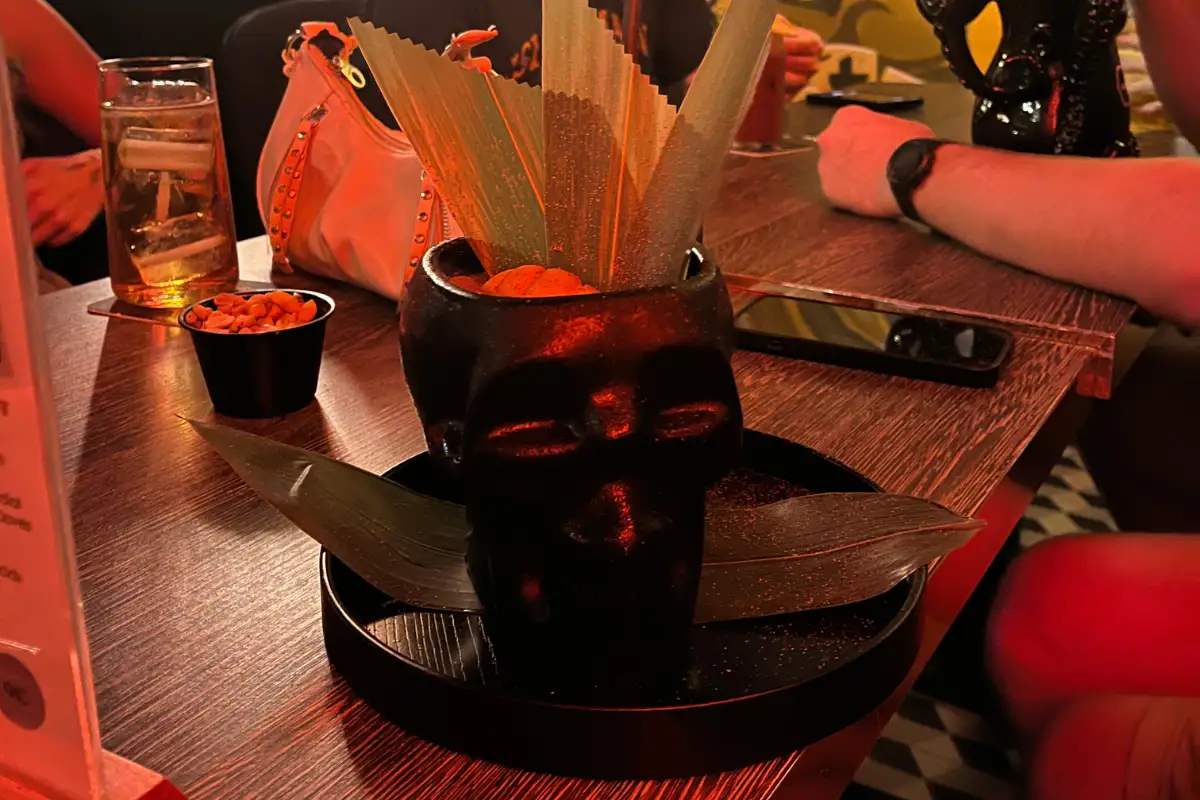 A cocktail served in a skull with palm fronds sticking out, served at Chester and Punk bar.