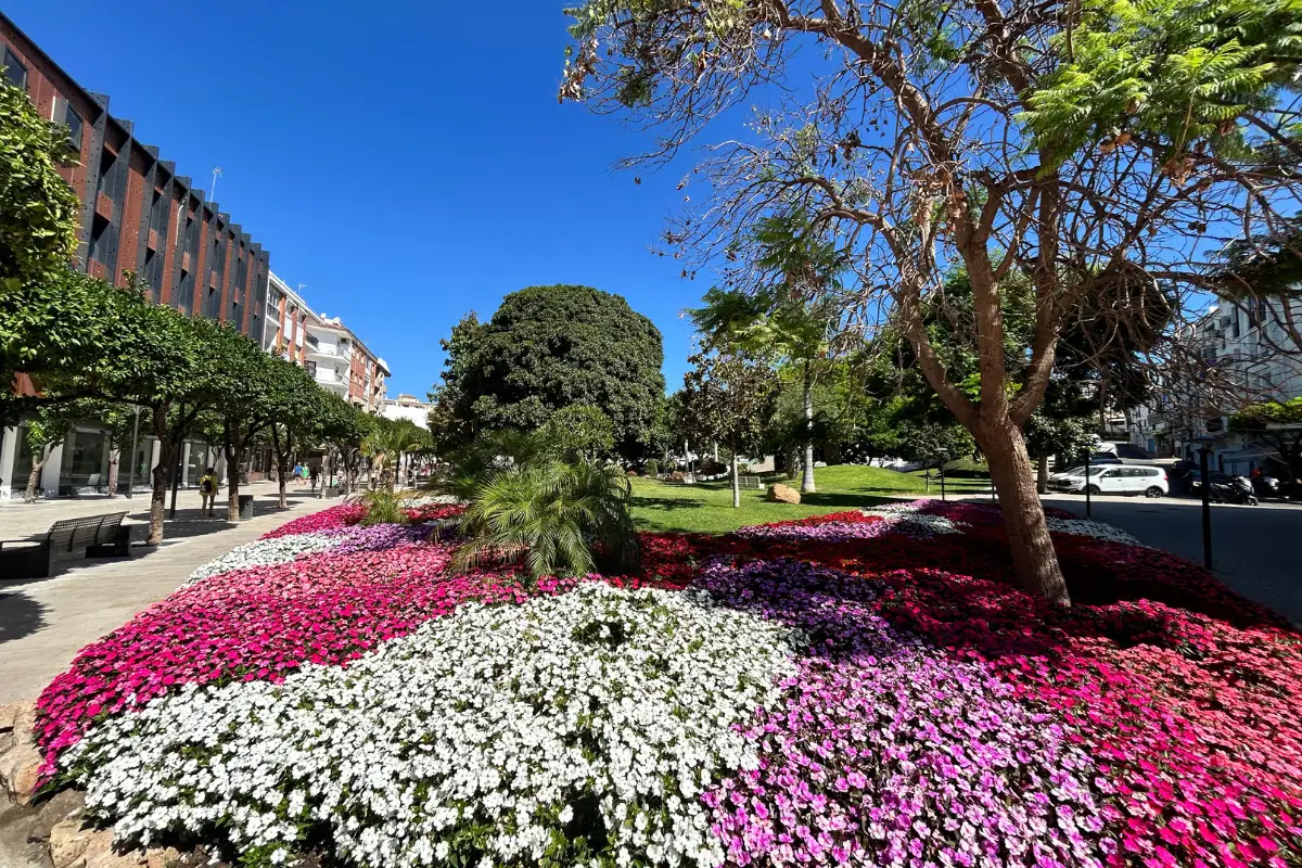 A park filled with flowers and lined with trees in Estepona Old Town.
