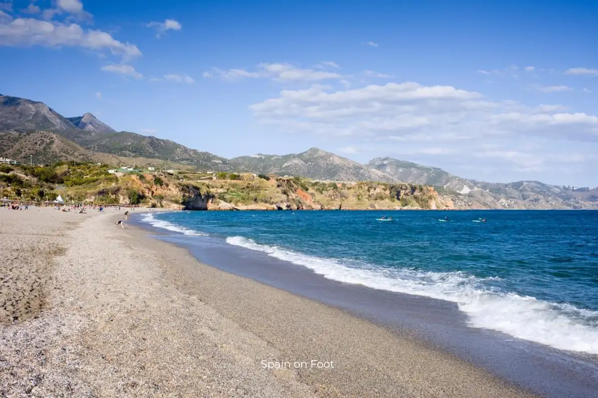 golden beach, blue ocean, and mountains in the background at playa el padron.