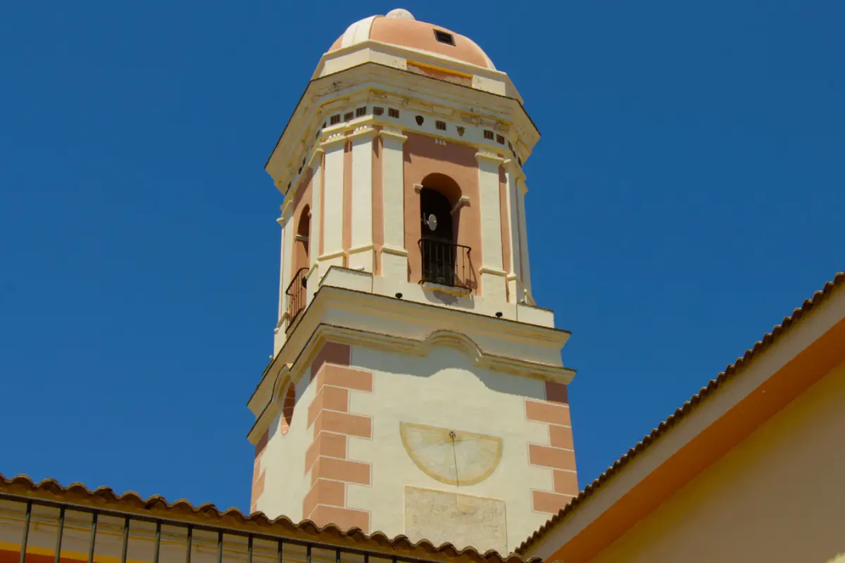 the spire of Torre del Reloj in Estepona with a blue sky background.