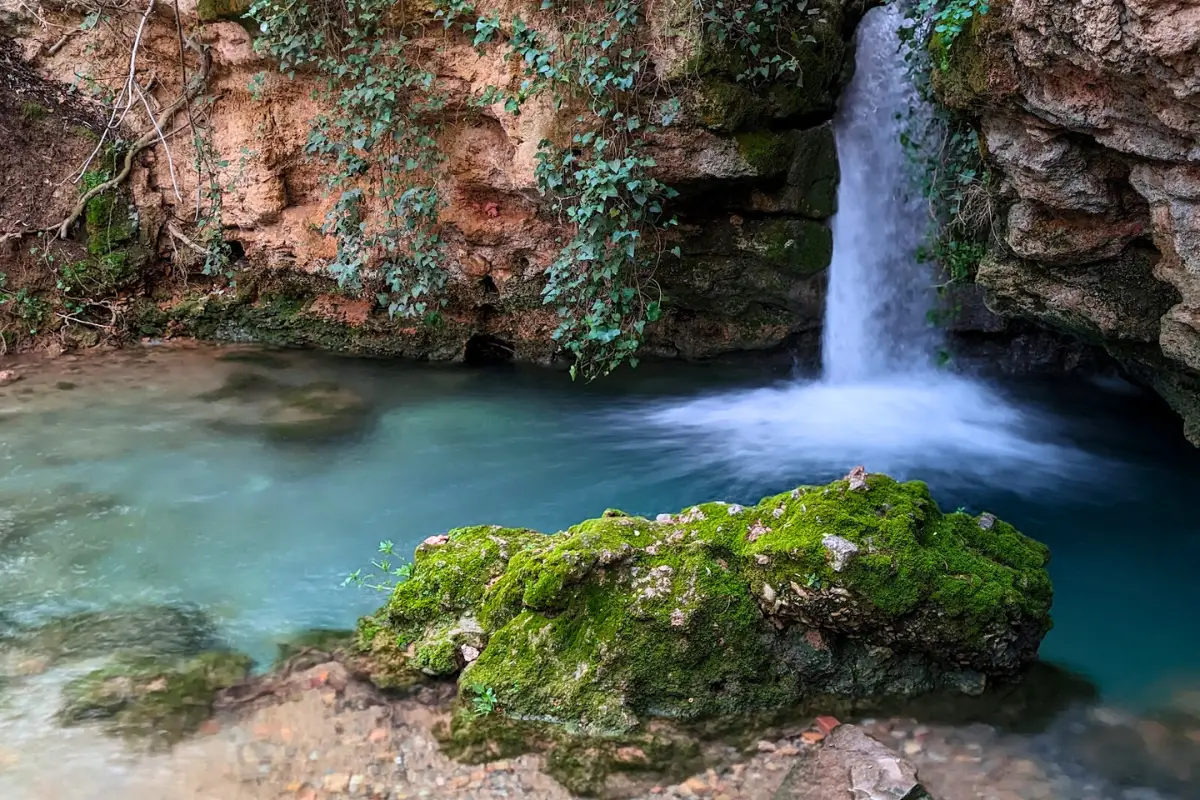 Waterfall and lush greenery at Jabacluz Gardens near Jaén