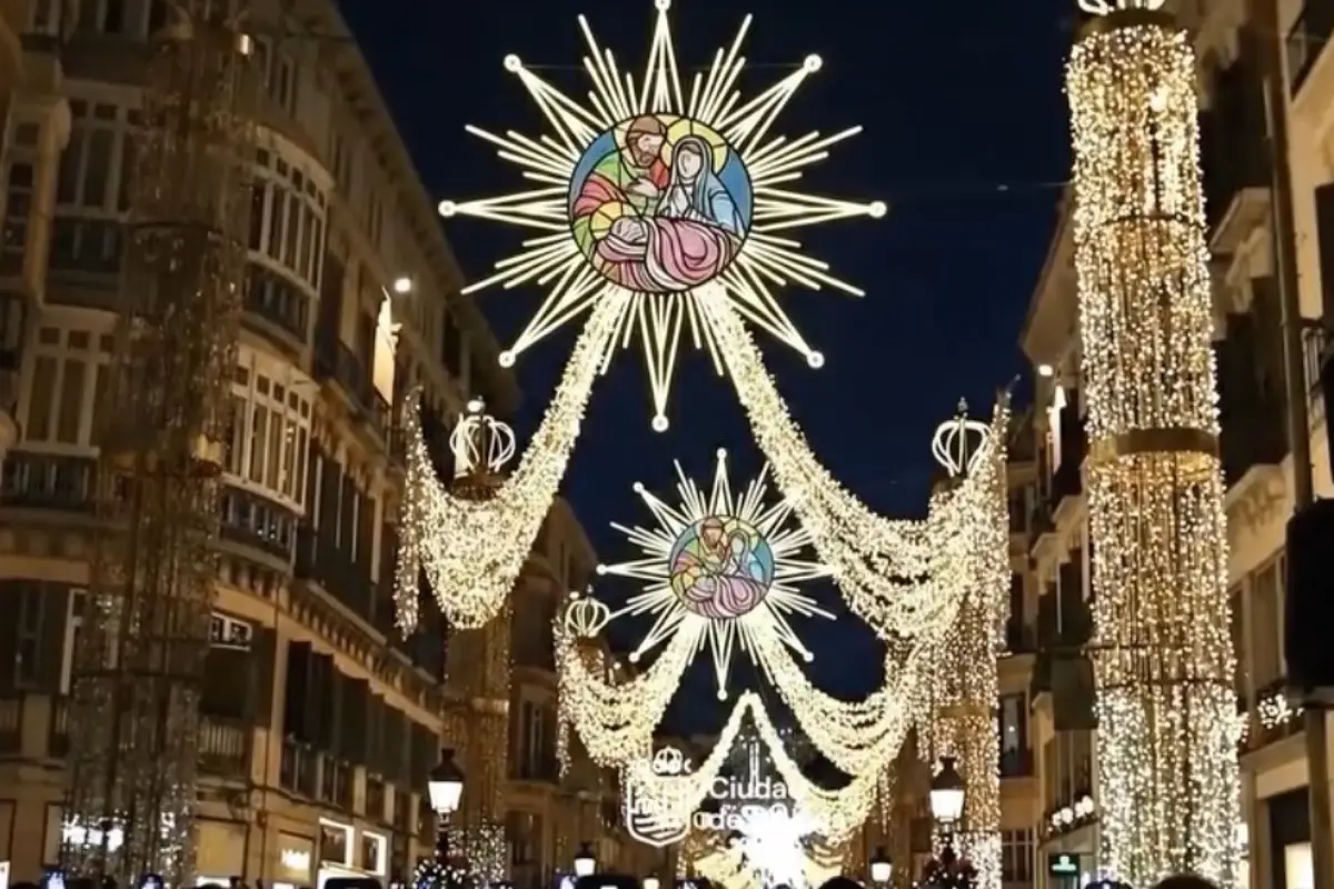 Golden Christmas lights stretching down Calle Larios seen from the end of the street.