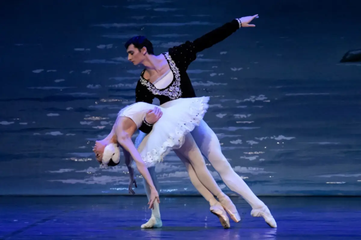 A man in a black leotard holding a woman in a white tutu at the Malaga Christmas Nutcracker show.