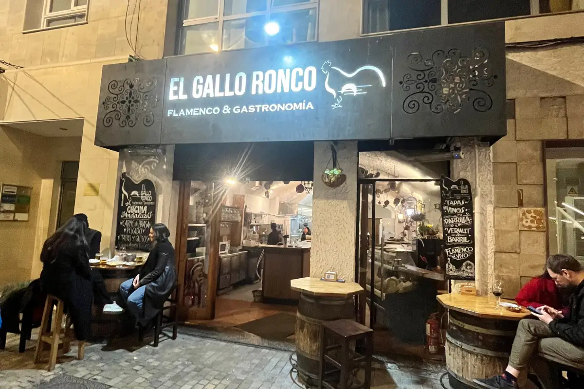 people seated outside the entrance to El Gallo Ronco in Malaga.