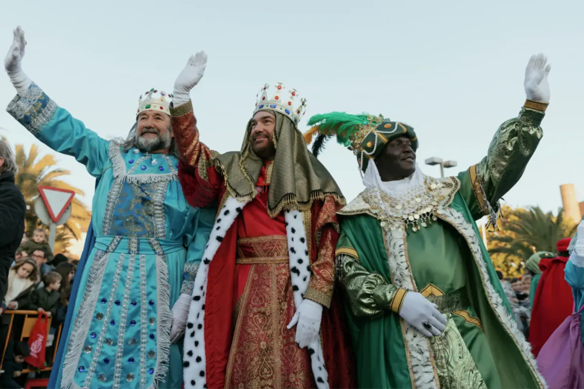 The three kings in blue, red and green waving to the crowds.