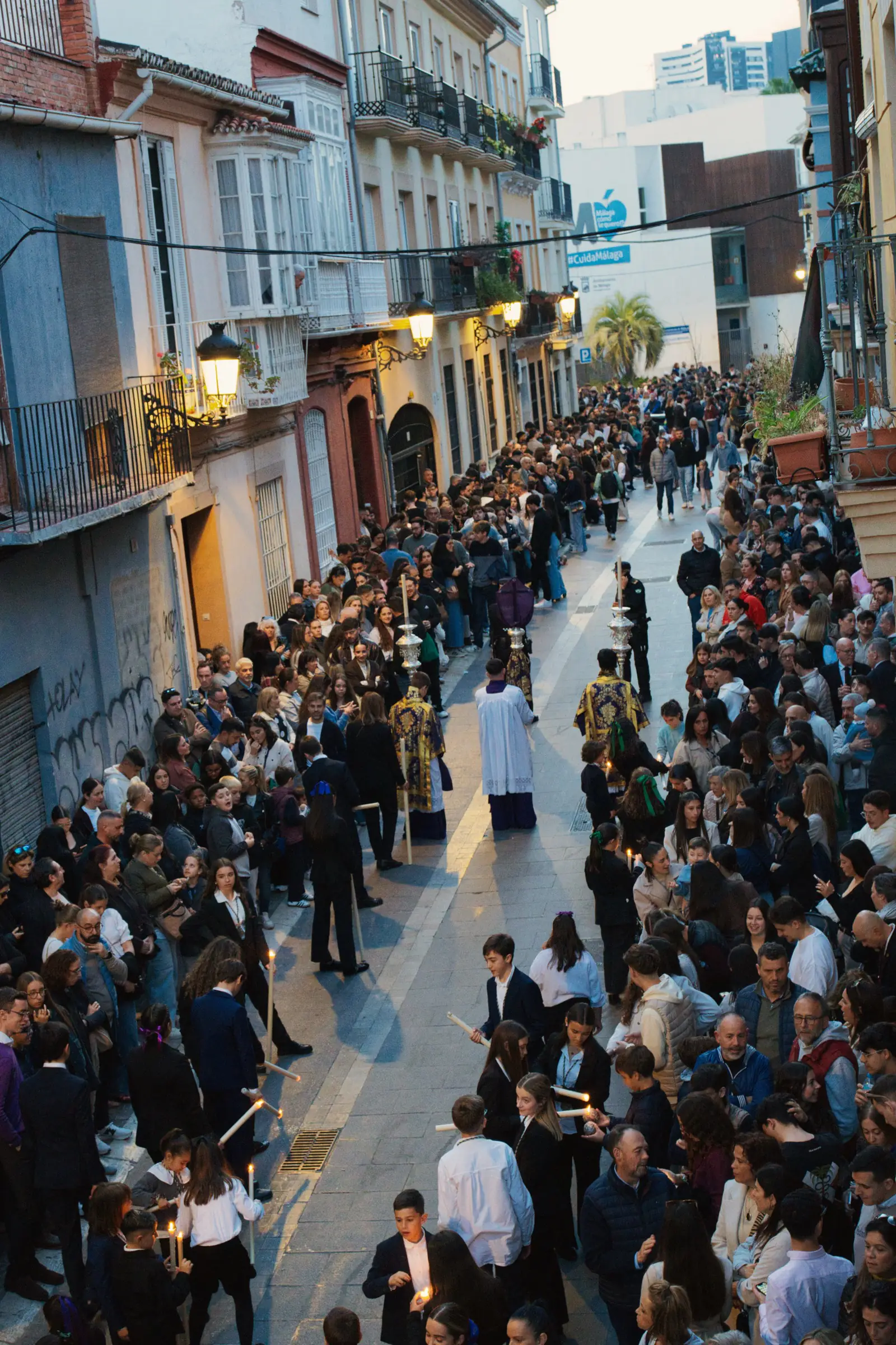 Candlelit Semana Santa procession moving through a narrow Málaga street at night