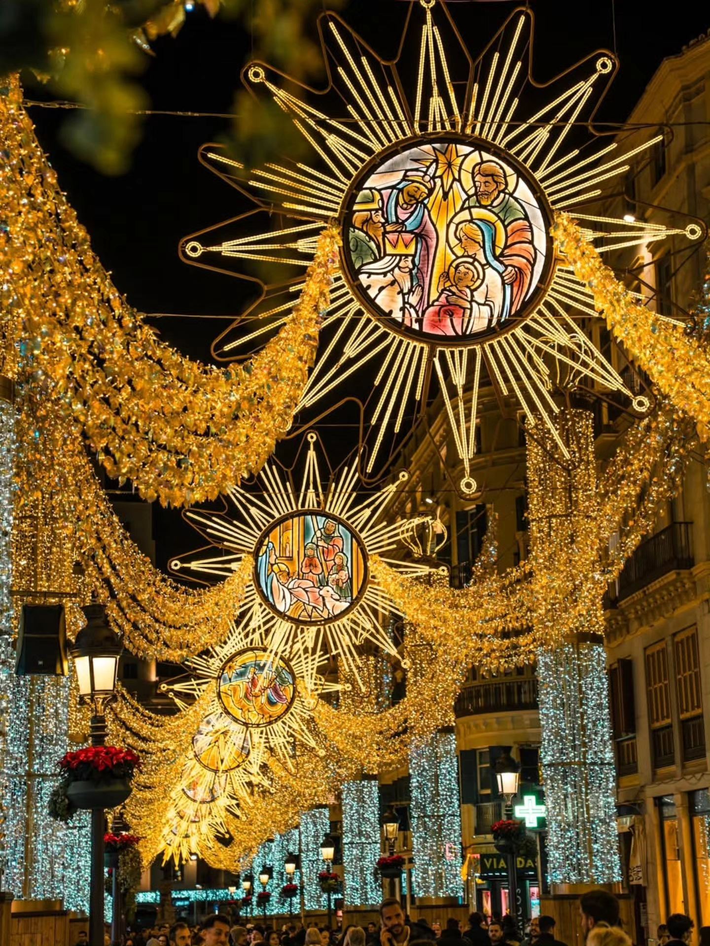 Golden nativity star Christmas lights on Calle Larios in Málaga at night
