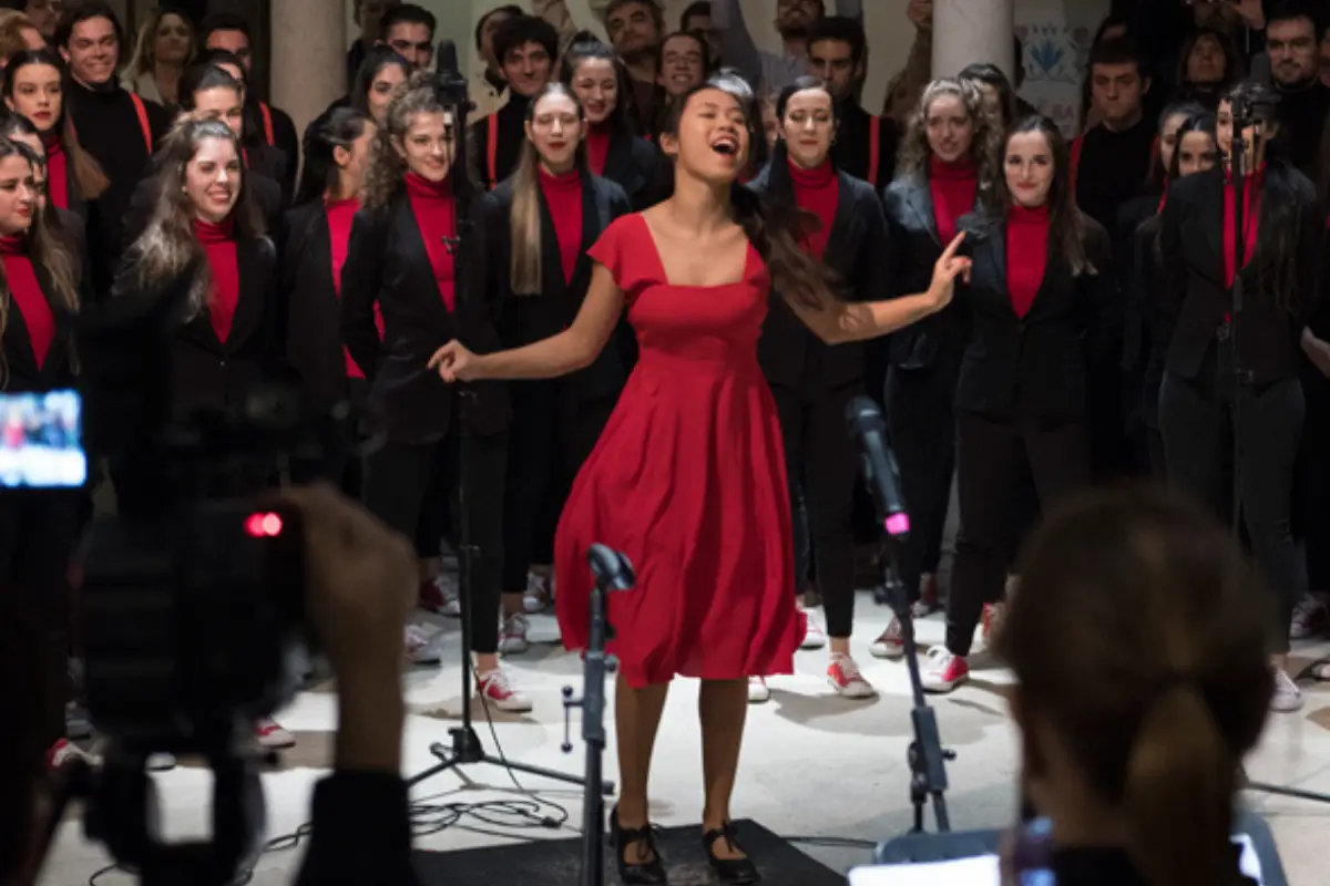 Singer in a red dress performing at a free Christmas concert in the Carmen Thyssen Museum courtyard
