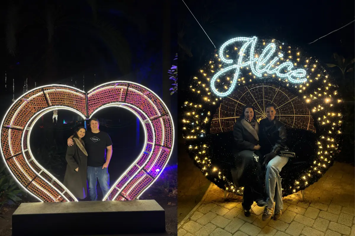 Couple posing inside an illuminated heart installation at Alice Christmas in Malaga