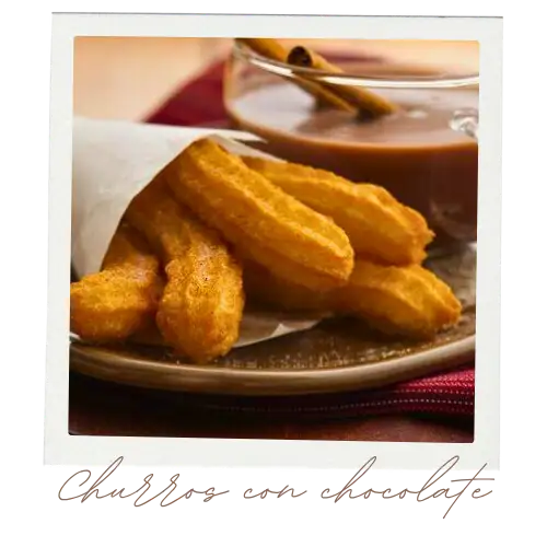 Five churros standing in a paper bag on a plate