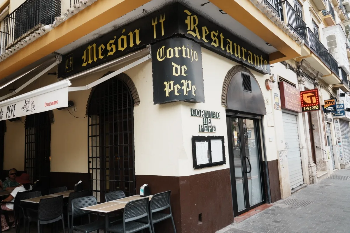 The corner of Cortijo de Pepe on Plaza de la Merced, its Mesón Restaurante sign over the awning and terrace tables set outside