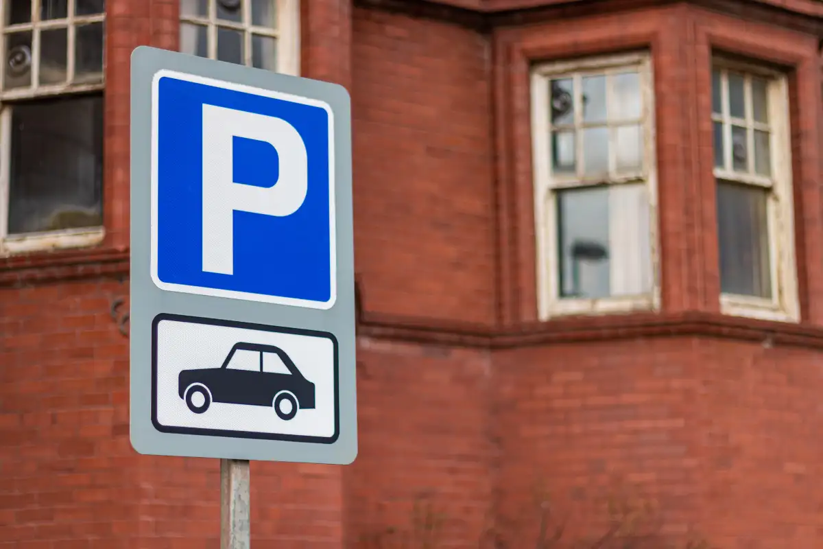 Blue parking sign in front of a brick building in Malaga
