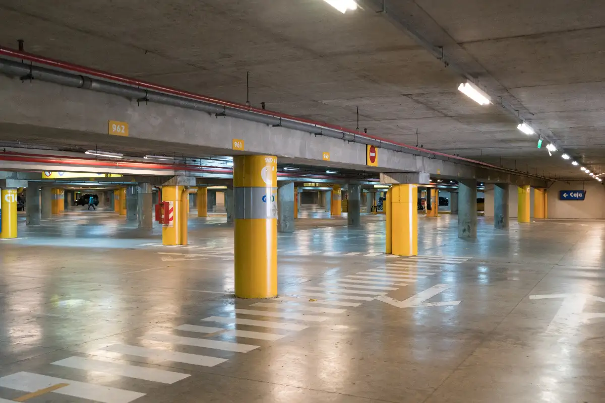 Empty underground parking garage in Malaga with numbered spaces and yellow support pillars