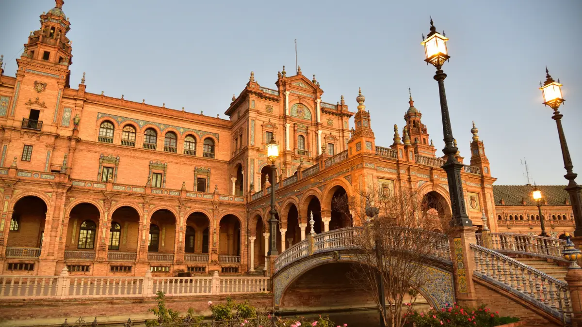 Ornate facade of the Plaza de España in Seville lit by warm evening light