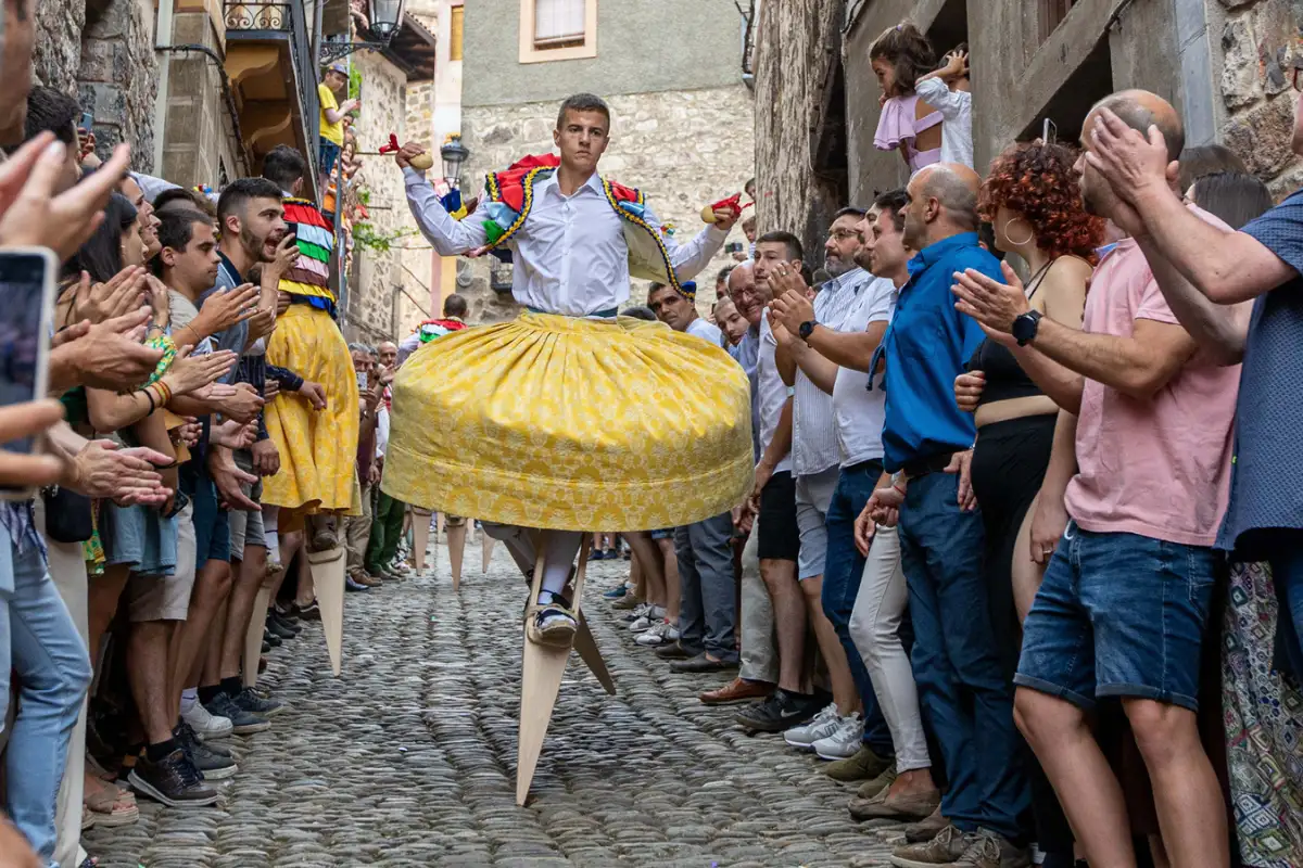 A costumed stilt dancer performing at a Spanish street festival