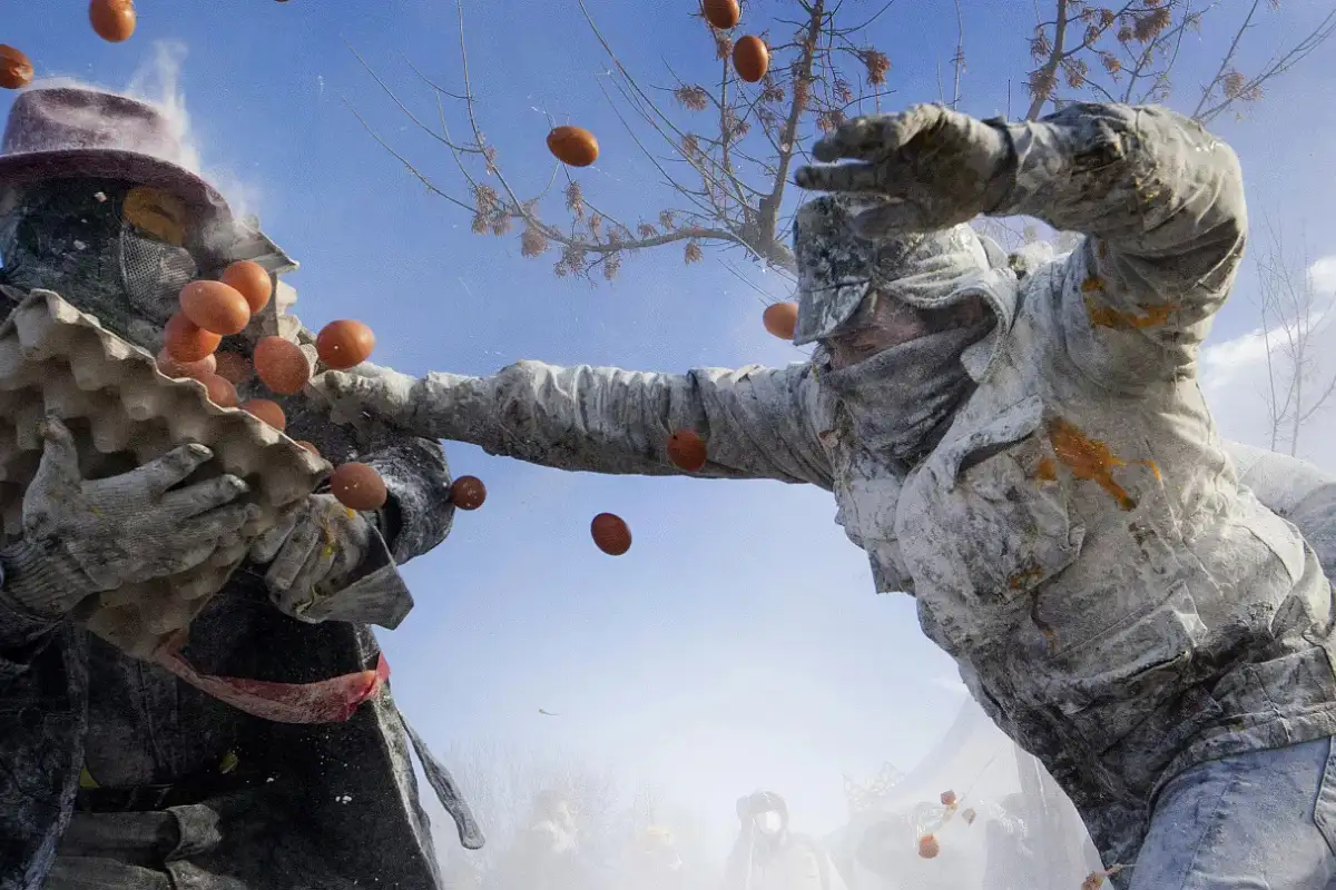 Flour-covered revellers in the street battle of Los Enharinados in Ibi, Alicante