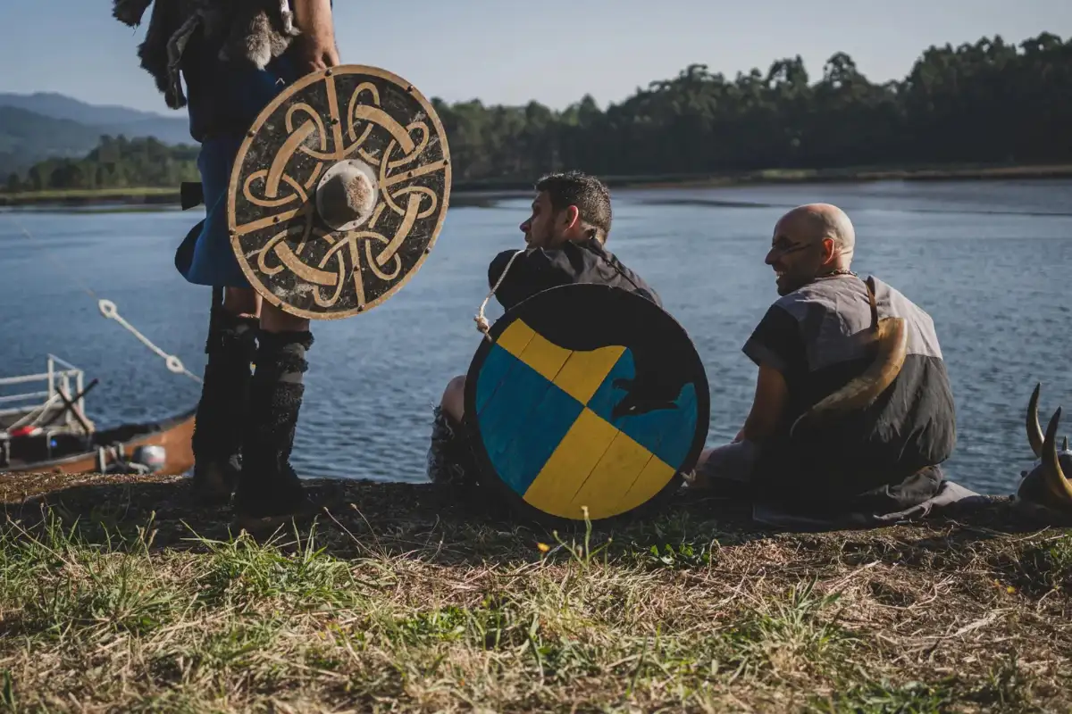 Viking-costumed participants in longboats at Romeria Vikinga in Catoira, Galicia